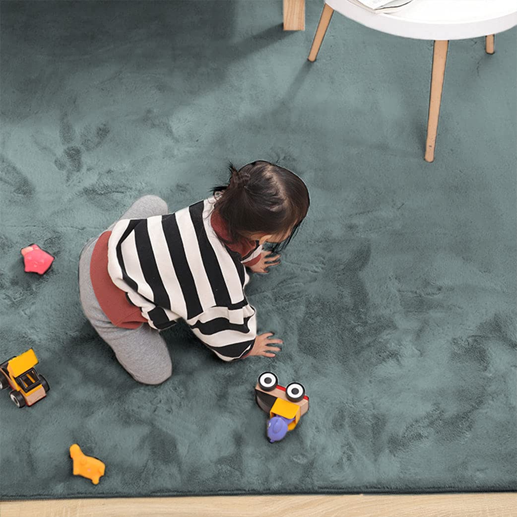 Child playing on a grey rabbit fur carpet with toys