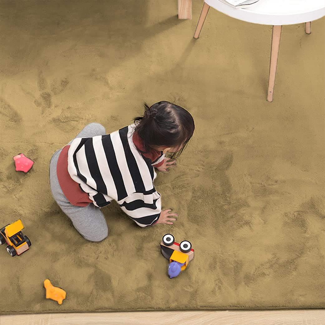 Child playing with toys on a golden camel rabbit fur carpet