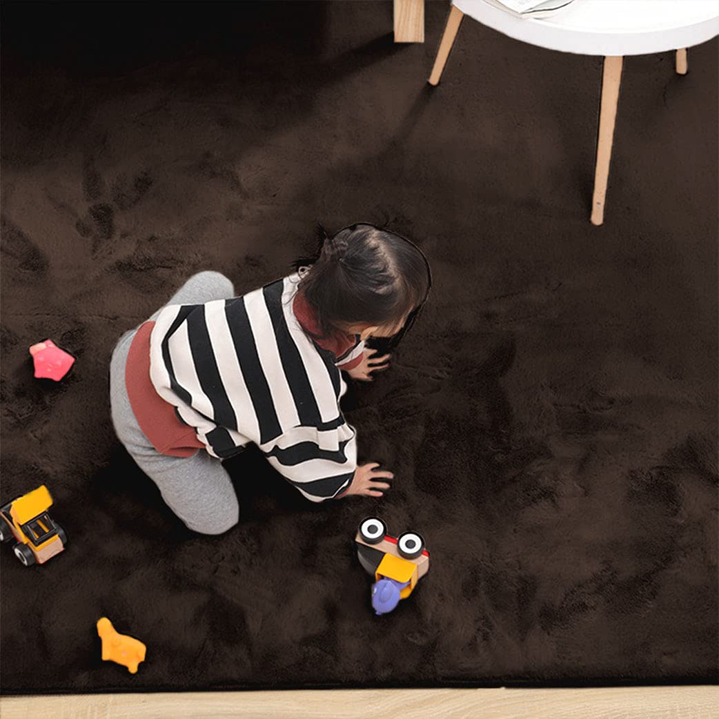 Child playing on a brown rabbit fur rug with toys