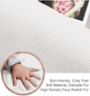 Close-up of a soft, plush white rabbit fur carpet with a hand touching it, highlighting its texture and comfort.