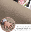 Close-up of a soft, taupe rabbit fur carpet with a hand touching it