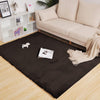 Brown rabbit fur rug on a wooden floor with a beige sofa and decorative items in the background