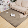 taupe rabbit fur carpet in a living room with a beige sofa and decorative items.