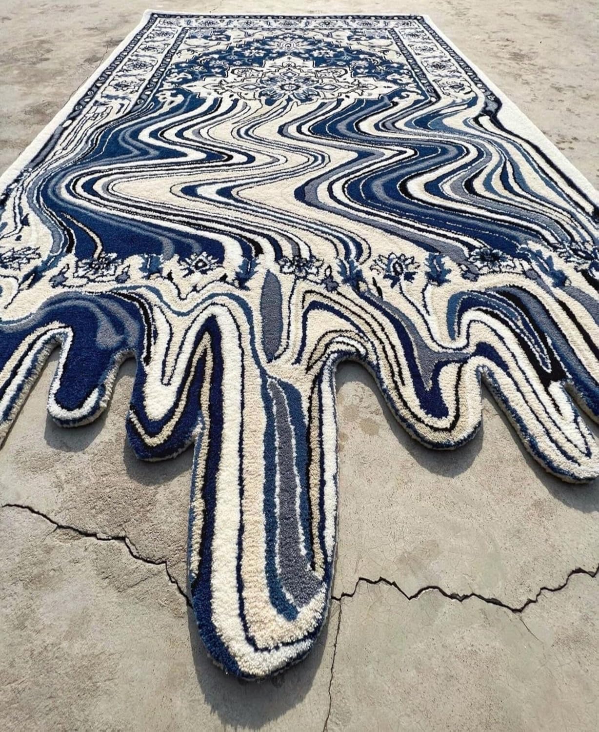 Blue hand-tufted wool rug with abstract wavy melting pattern on a neutral floor