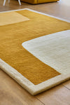 Close-up of geometric mustard area rug on wooden floor
