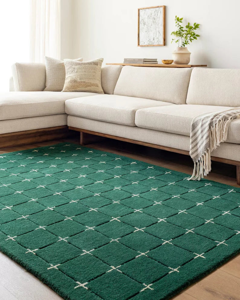 Emerald green geometric wool rug in a modern living room with cream sofa