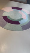 Luna pastel round rug in multicolor soft tones on wooden flooring