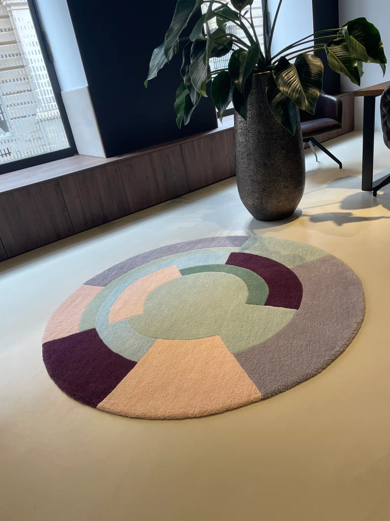Round hand tufted rug in pastel tones near modern bench and plant