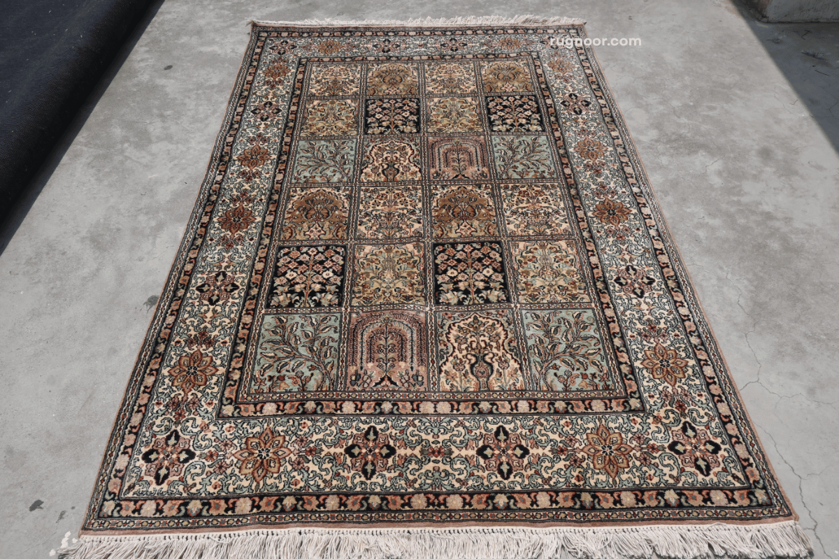 Full view of Persian heritage garden panel rug with ivory ground, floral botanical panels and layered border — Rugnoor collection