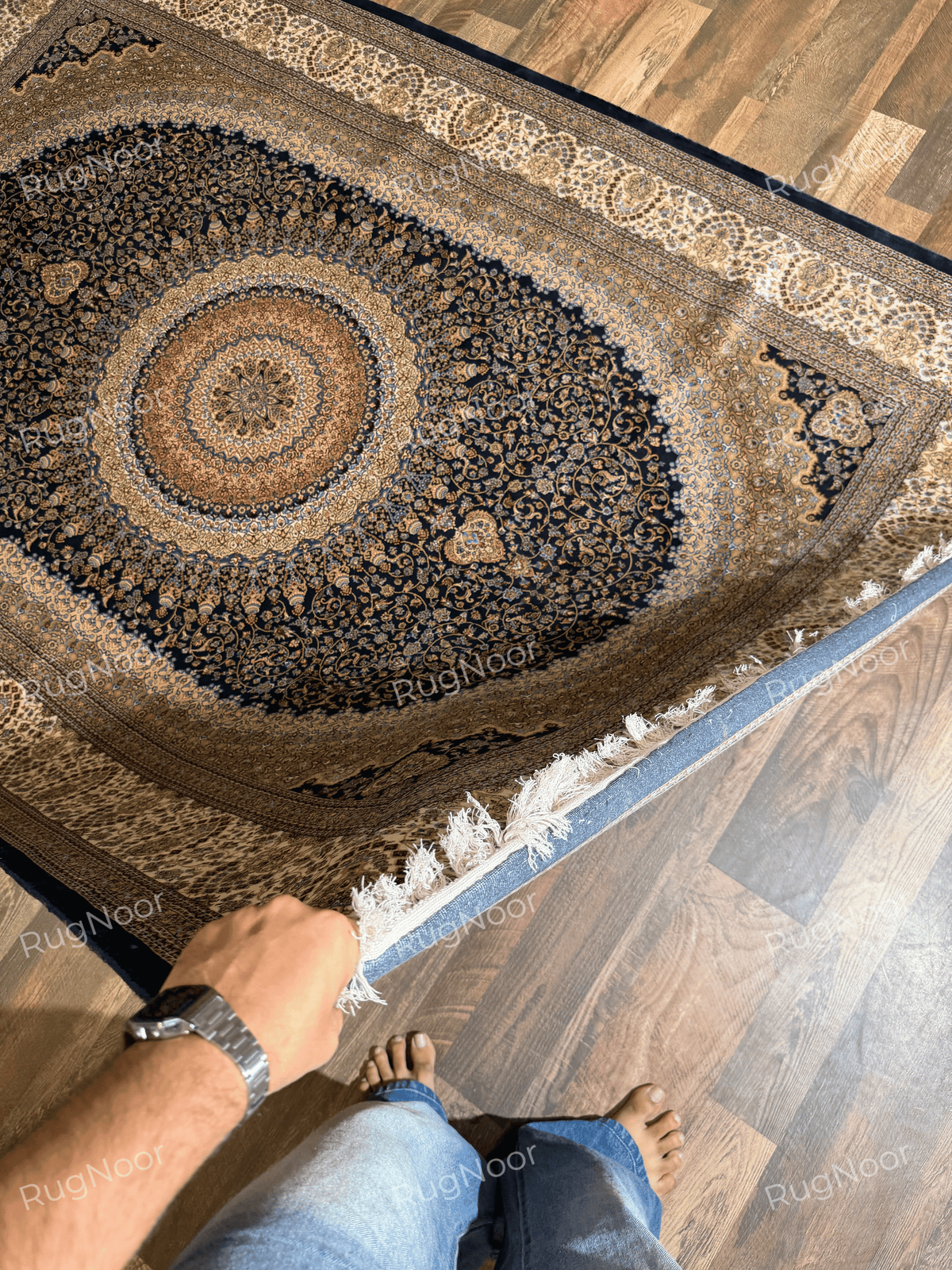 Shabafruz rug lifted at one corner, showing the navy floral field, circular medallion, and ivory fringe.