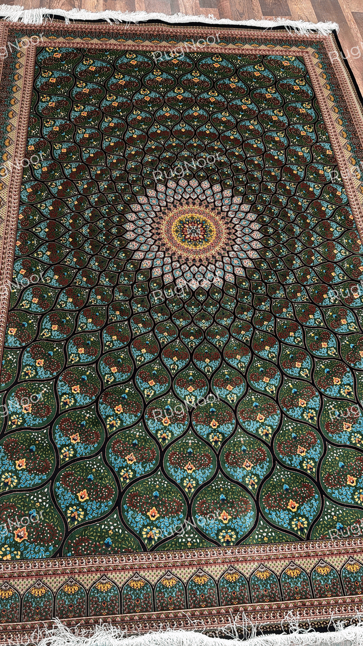 Full overhead view of Tawus carpet displaying its symmetrical green floral design and decorative borders.