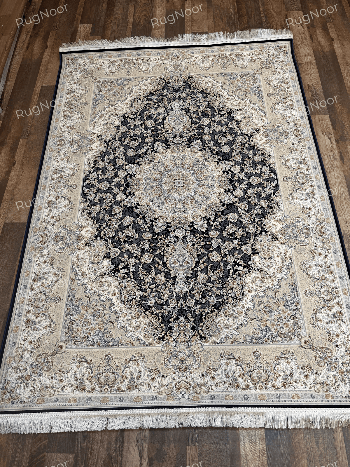 Full view of the black Irani carpet with an ivory medallion and decorative borders