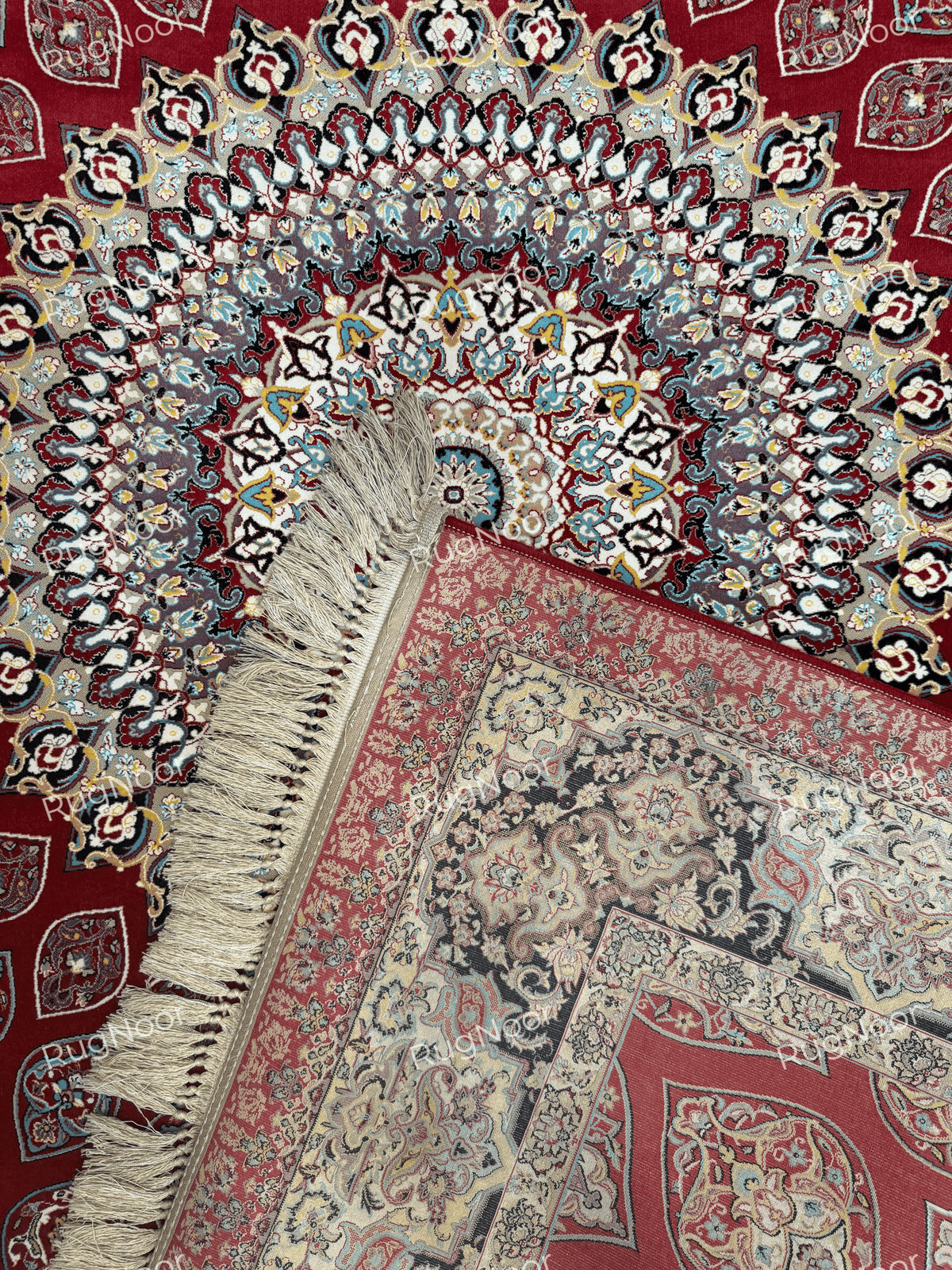 Red Irani carpet showing ornate floral borders, cream fringe, and folded corner