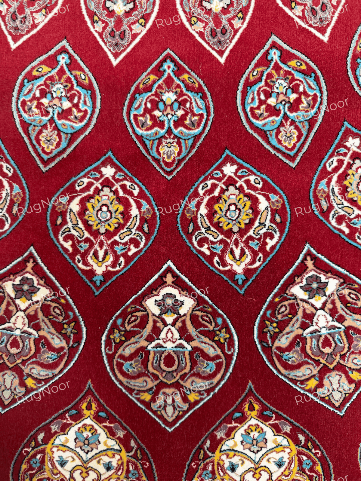 Close-up of multicolour floral motifs on the red carpet field