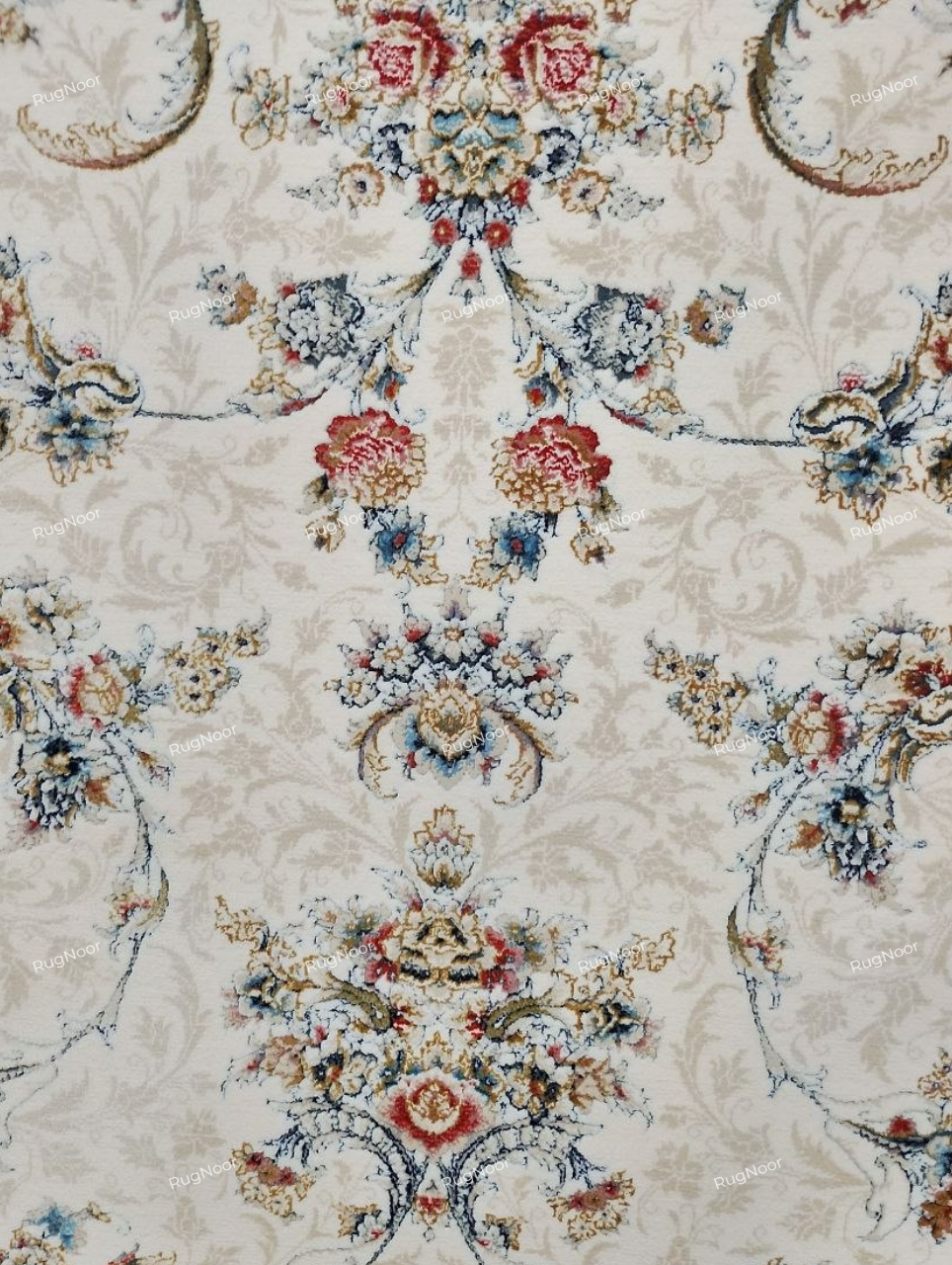 Detailed view of Mehravi's central floral pattern with symmetrical ornamental motifs, fine beige scrolling vines, and blue, rust and gold accents on ivory.