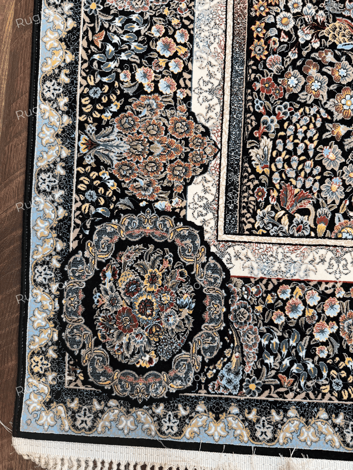 Close-up of a floral corner medallion and cream decorative border on the black carpet by RugNoor