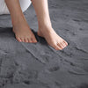 Close-up of feet on a dark gray rabbit fur carpet