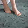 Feet stepping on a grey rabbit fur carpet