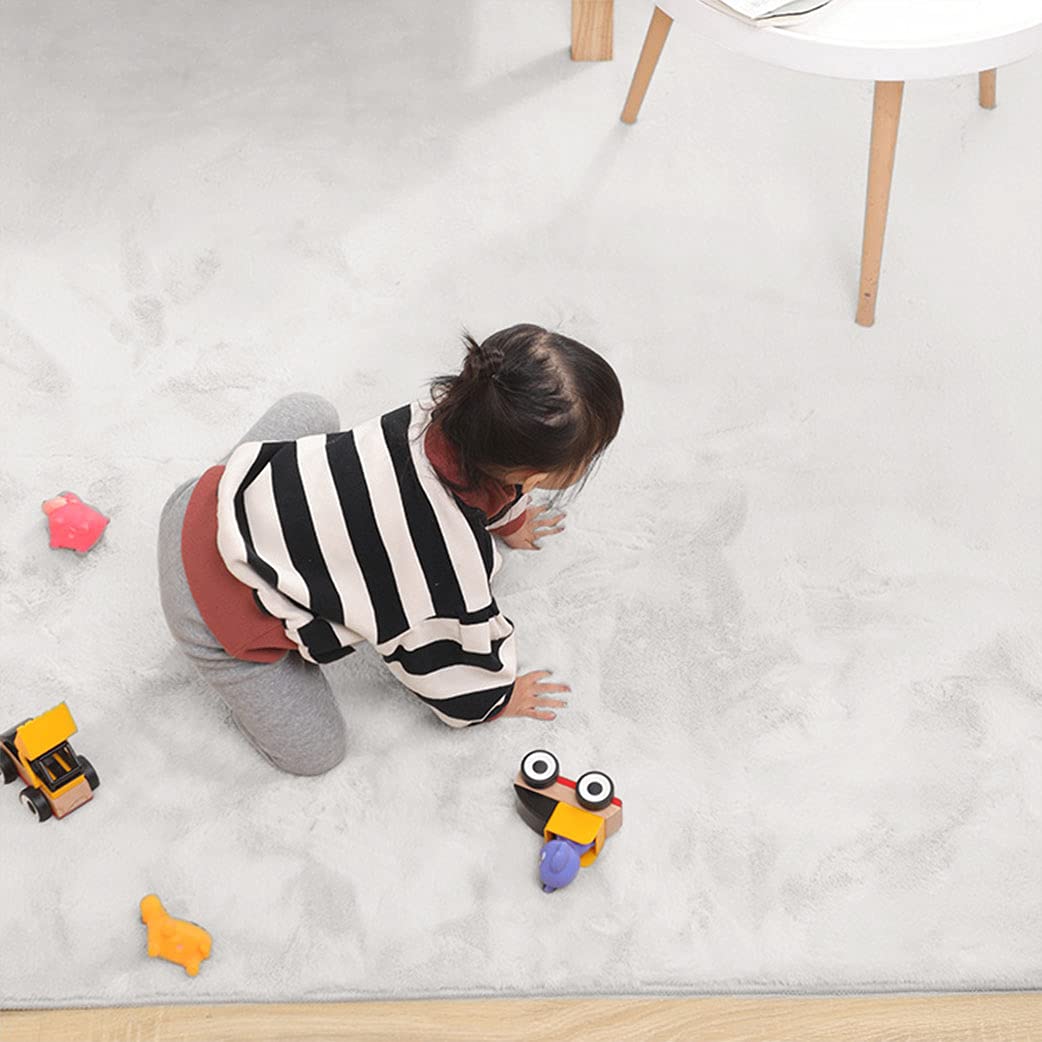 Child playing on a soft white rabbit fur carpet with toys