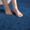 Feet laying on a blue rabbit fur carpet