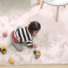 Child playing on a soft ivory rabbit fur carpet with toys