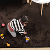Child playing on a brown rabbit fur rug with toys