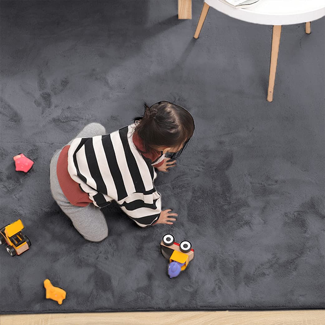 Child playing with toys on a dark gray rabbit fur carpet