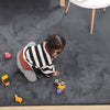 Child playing with toys on a dark gray rabbit fur carpet