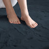 Feet standing on a dark blue rabbit fur carpet