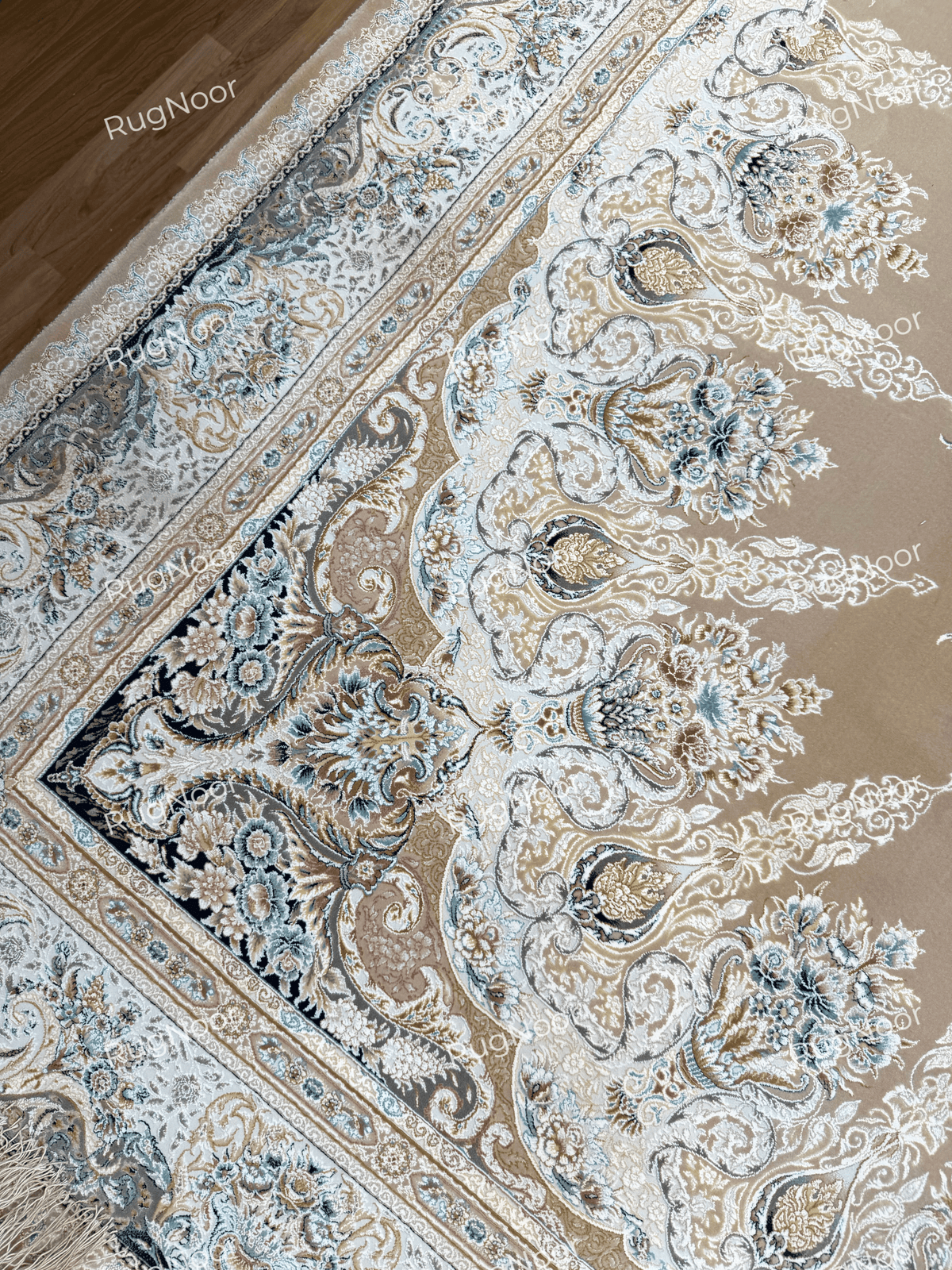 Angled view of Warda's ivory and grey border with ornate floral motifs and muted blue accents, RugNoor.