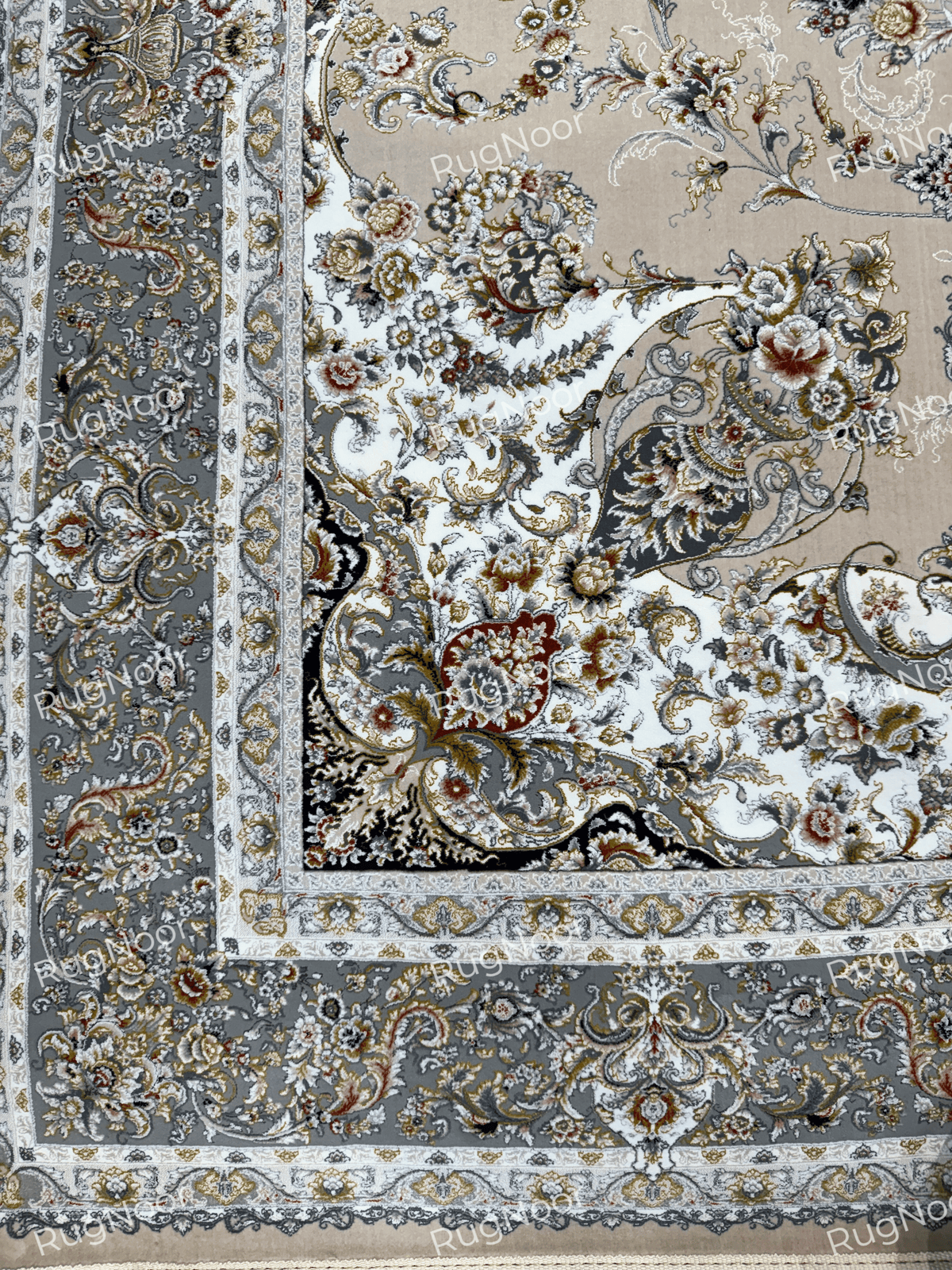 Corner view showing Urkeed's ornate beige floral field and contrasting grey decorative border, RugNoor.