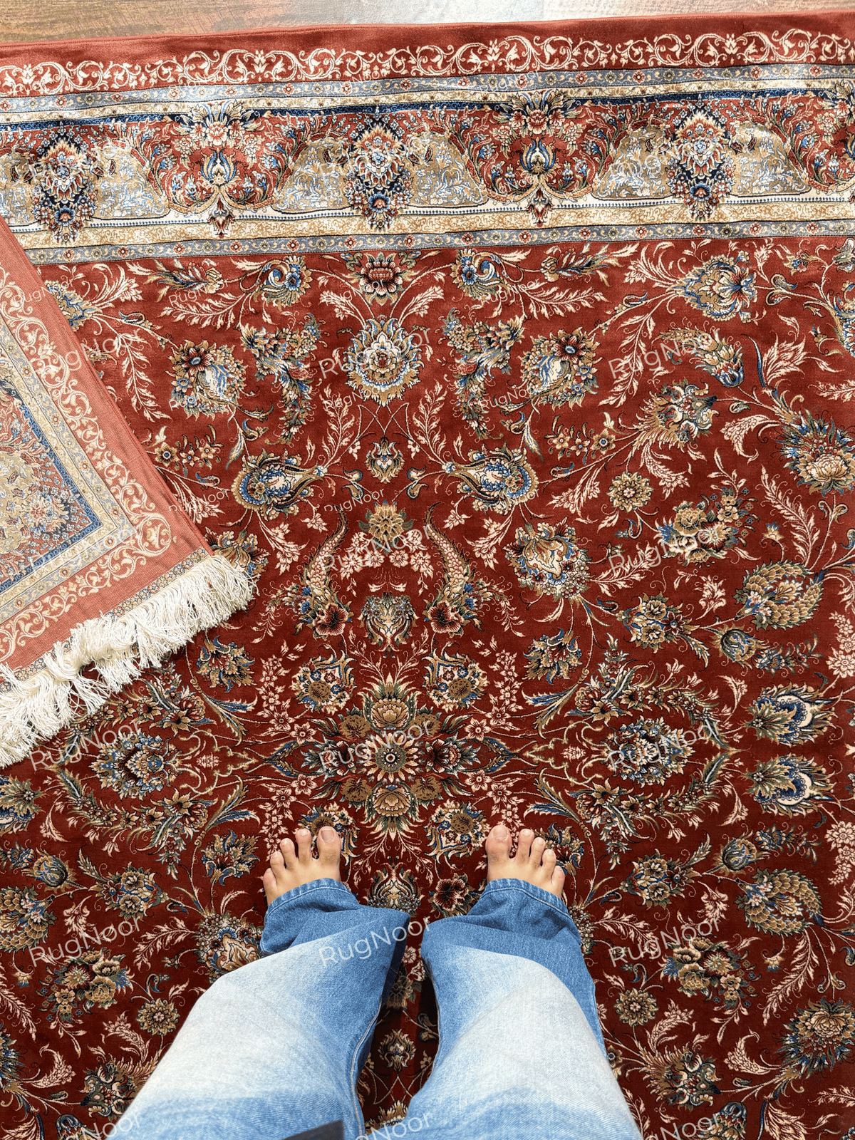 Atashgul rug with the lower-left corner folded back to reveal the pale patterned underside.