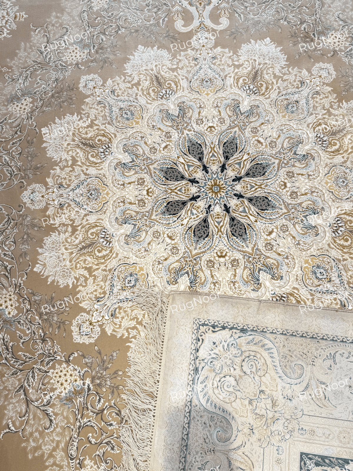 Warda's central floral medallion beside a folded corner showing the fringed edge and border, RugNoor.
