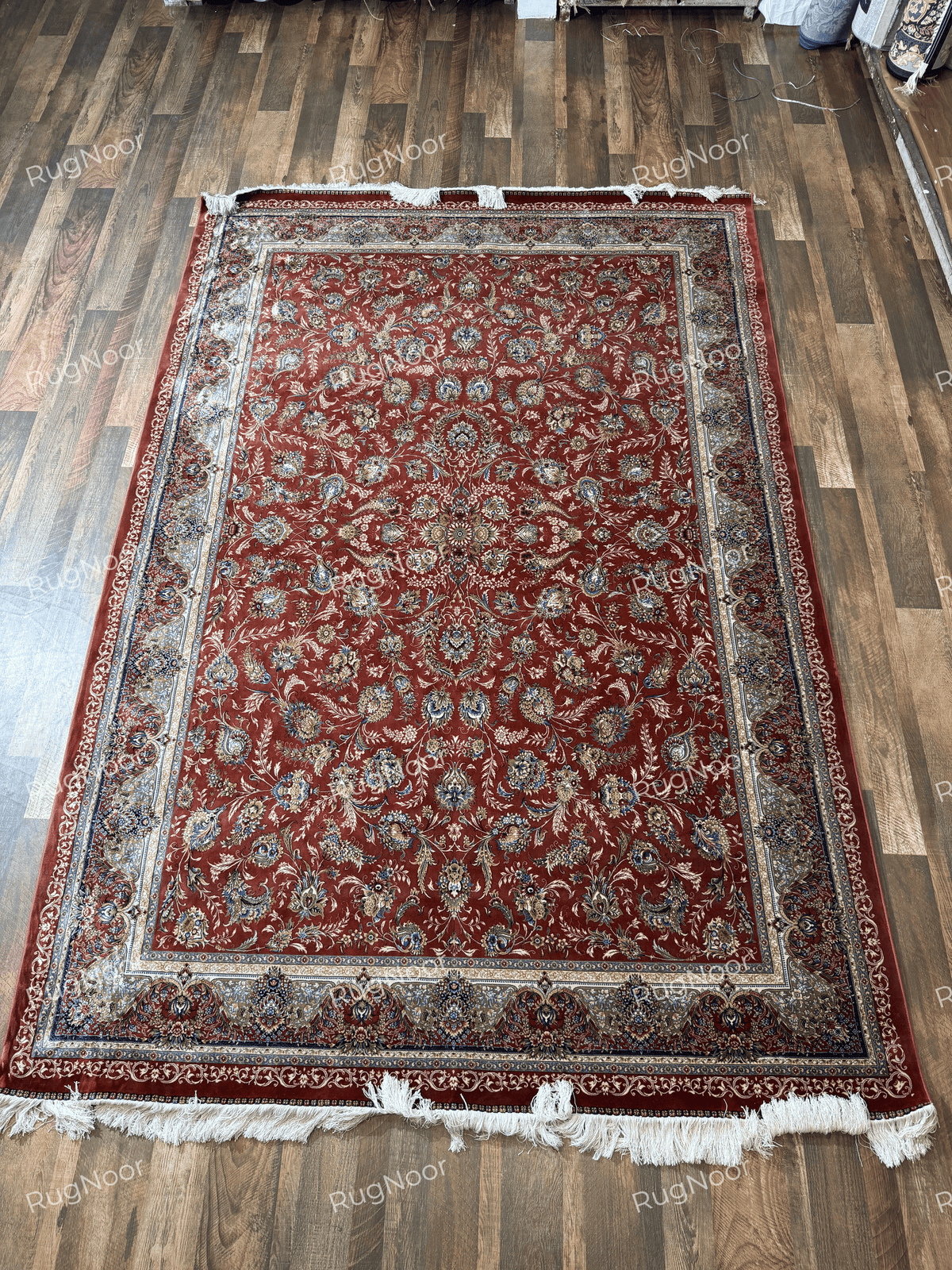 Full view of the Atashgul rug laid flat, showing its terracotta floral field and ivory-gold borders.