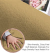 Close-up of a golden beige rabbit fur carpet with a hand touching it