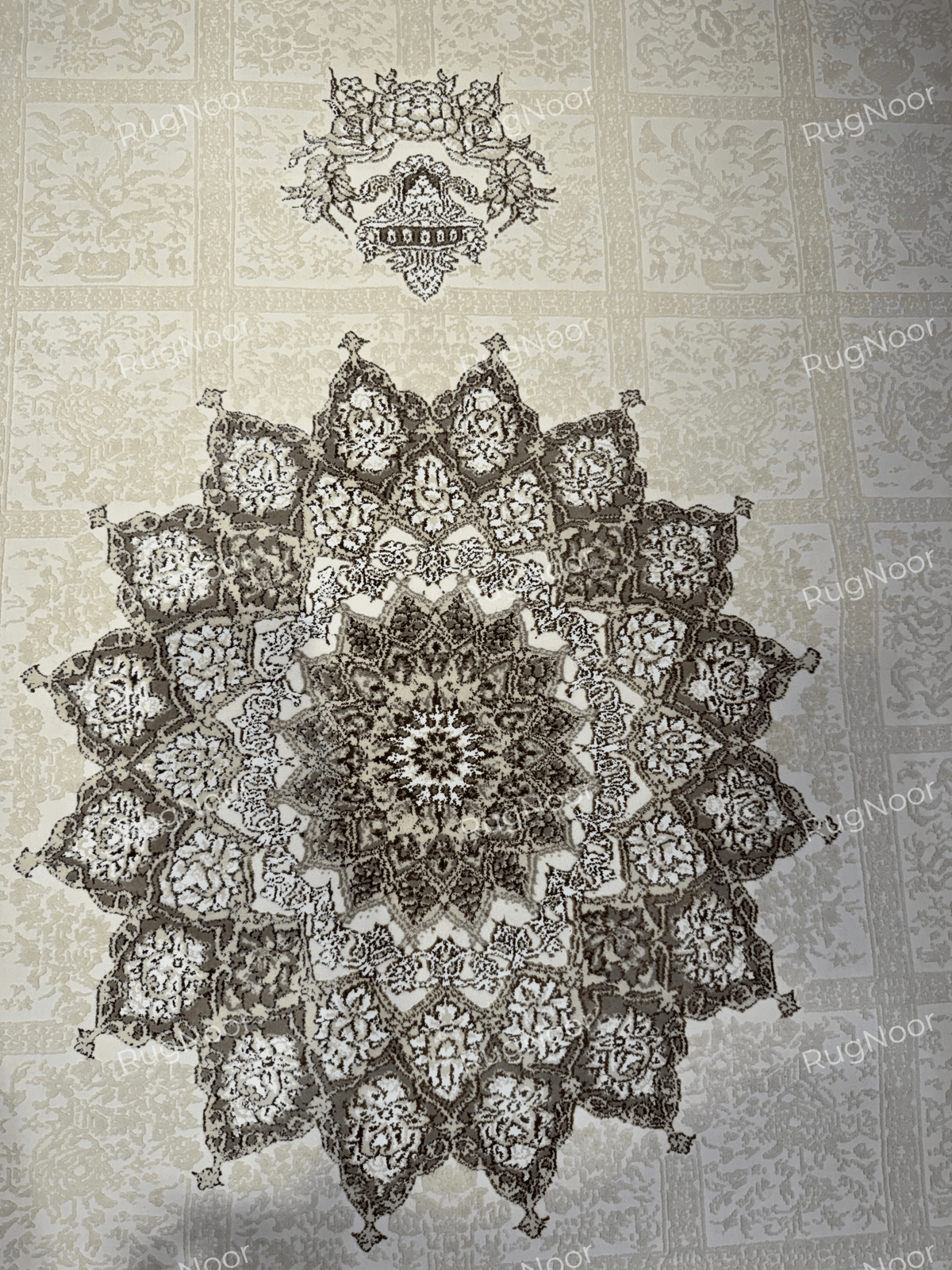 Close-up of the intricate floral star medallion with dark taupe and ivory detailing on Parichehr, RugNoor.