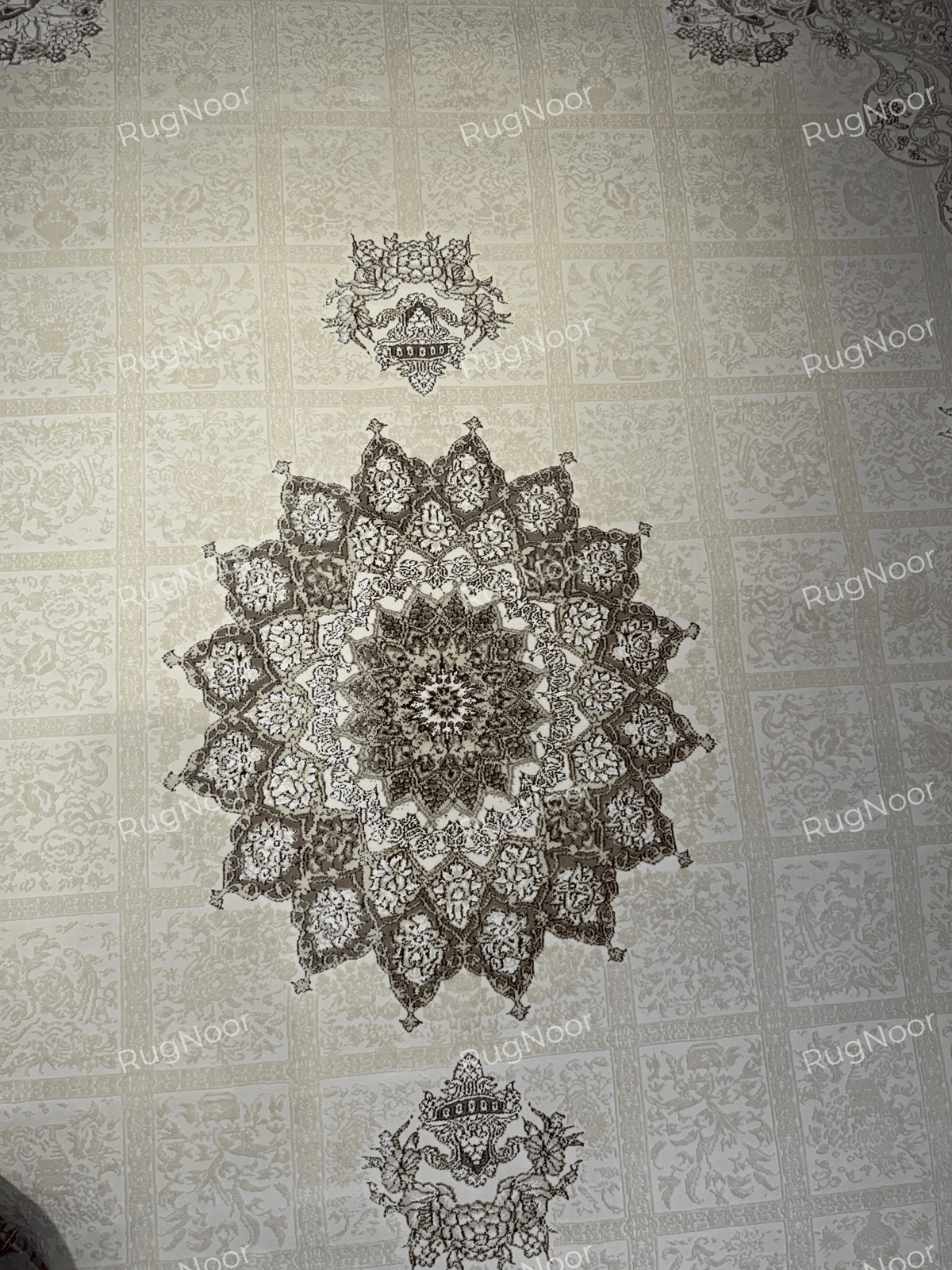 Detailed view of the layered star-shaped floral medallion and folded carpet corner on Parichehr, RugNoor.