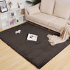 brown rabbit fur carpet on a wooden floor with a beige sofa and decorative items in the background
