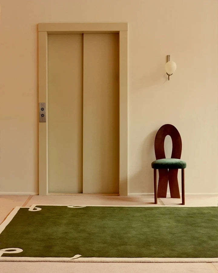 Astera olive green hand tufted wool rug adding minimalist elegance to a modern living space.