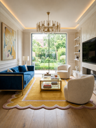 A modern living room featuring a deep blue velvet sofa with gold trim, two cream-colored armchairs, a yellow scalloped area rug, and a large glass window overlooking a green garden.