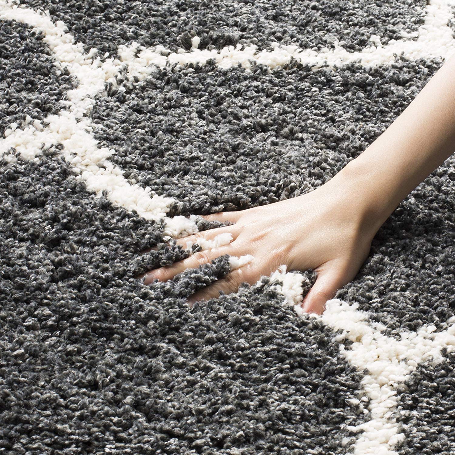 Hand touching a gray and white striped rug