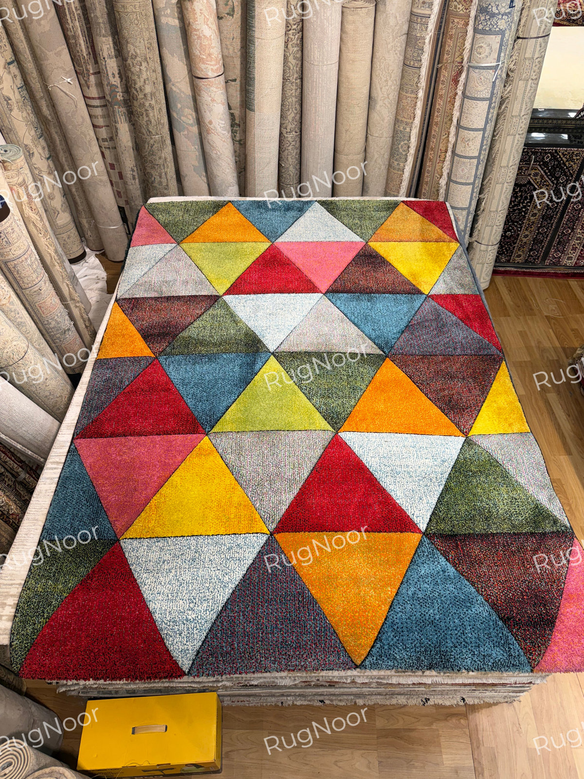 Full view of the Prismland carpet displaying its multicoloured triangle pattern arranged in rows across the rug. 