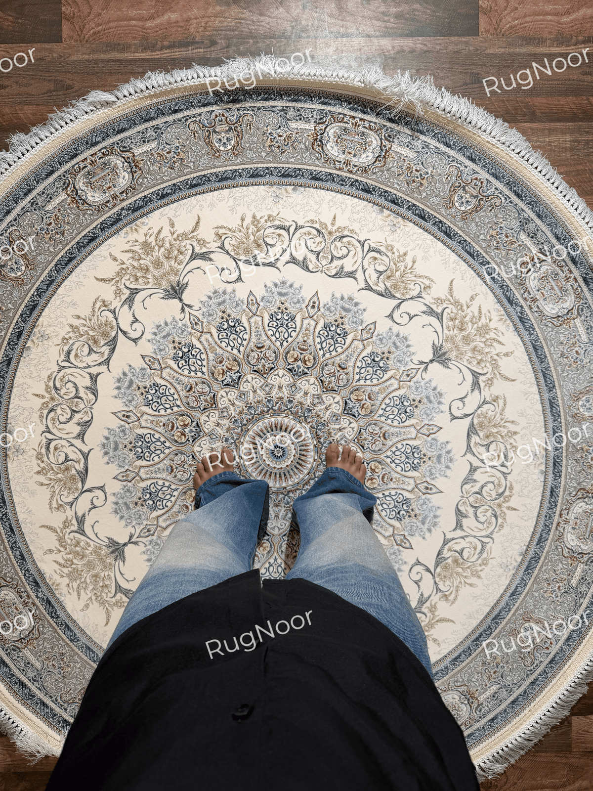 Mahzarin ivory round carpet shown with a person standing near the central medallion, displaying its floral detailing and overall pattern scale.