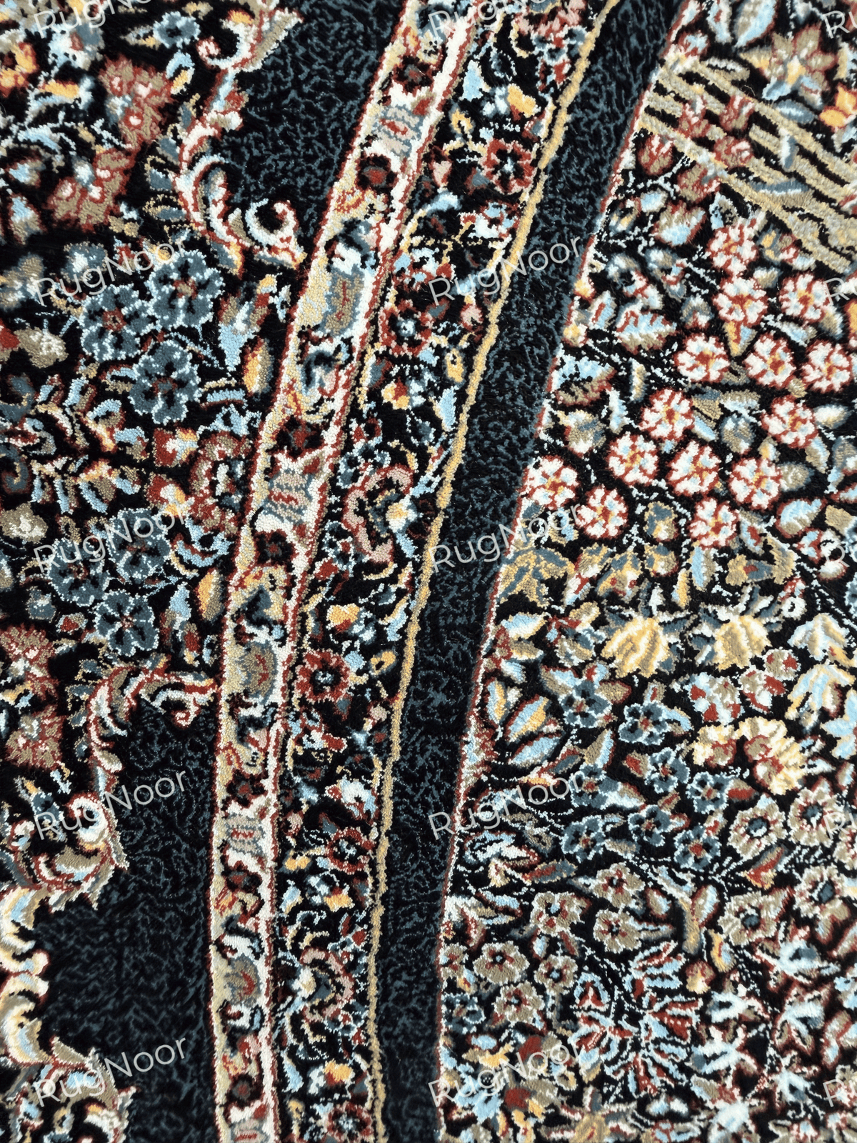 Detailed view of the Ravzaran carpet's dark outer border with narrow floral bands in ivory, muted blue, beige, and rust.