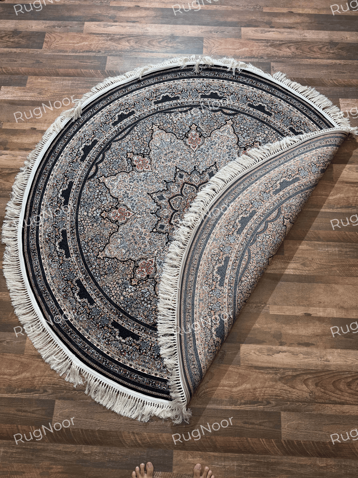 Ravzaran round floral medallion carpet folded back to reveal its central pattern, dark ornamental borders, and ivory fringe.