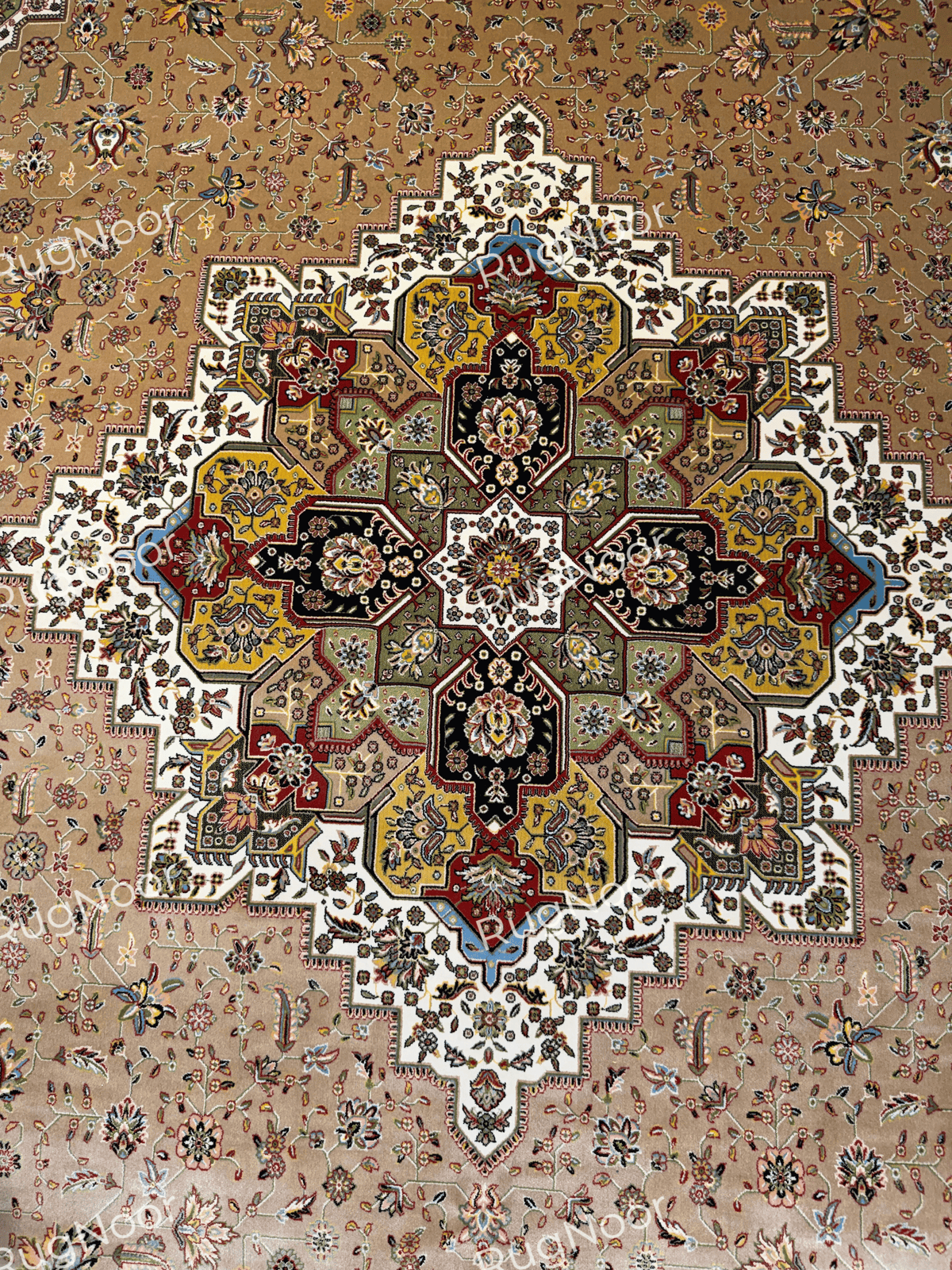 Close-up of the Anbara carpet's large multi-pointed floral medallion in black, burgundy, mustard, olive, ivory, and blue, surrounded by a camel-beige floral field.