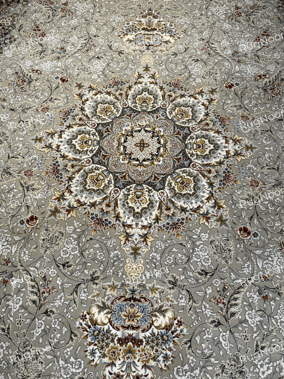 Central floral medallion surrounded by delicate ivory vines on the grey-taupe Zanbaq carpet, RugNoor.