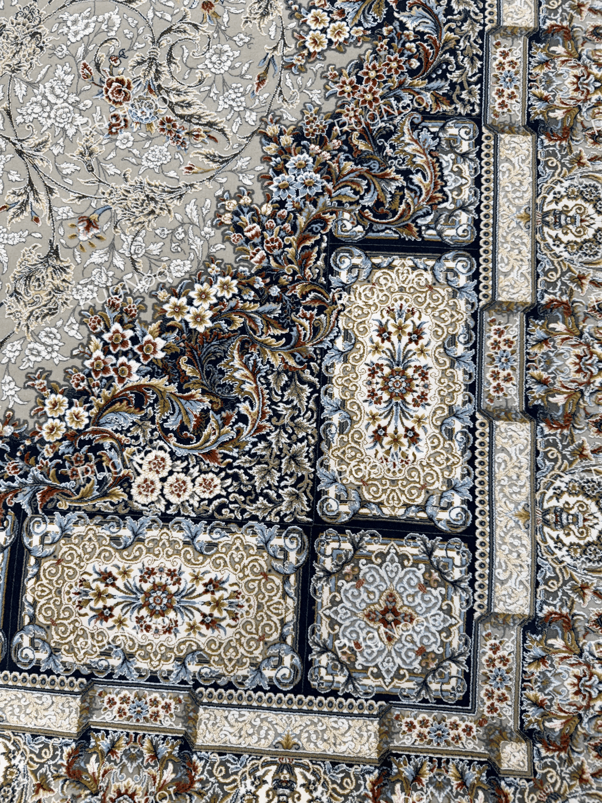 Close-up of the dark navy patterned border and ornamental floral detailing on the grey Zanbaq carpet, RugNoor.