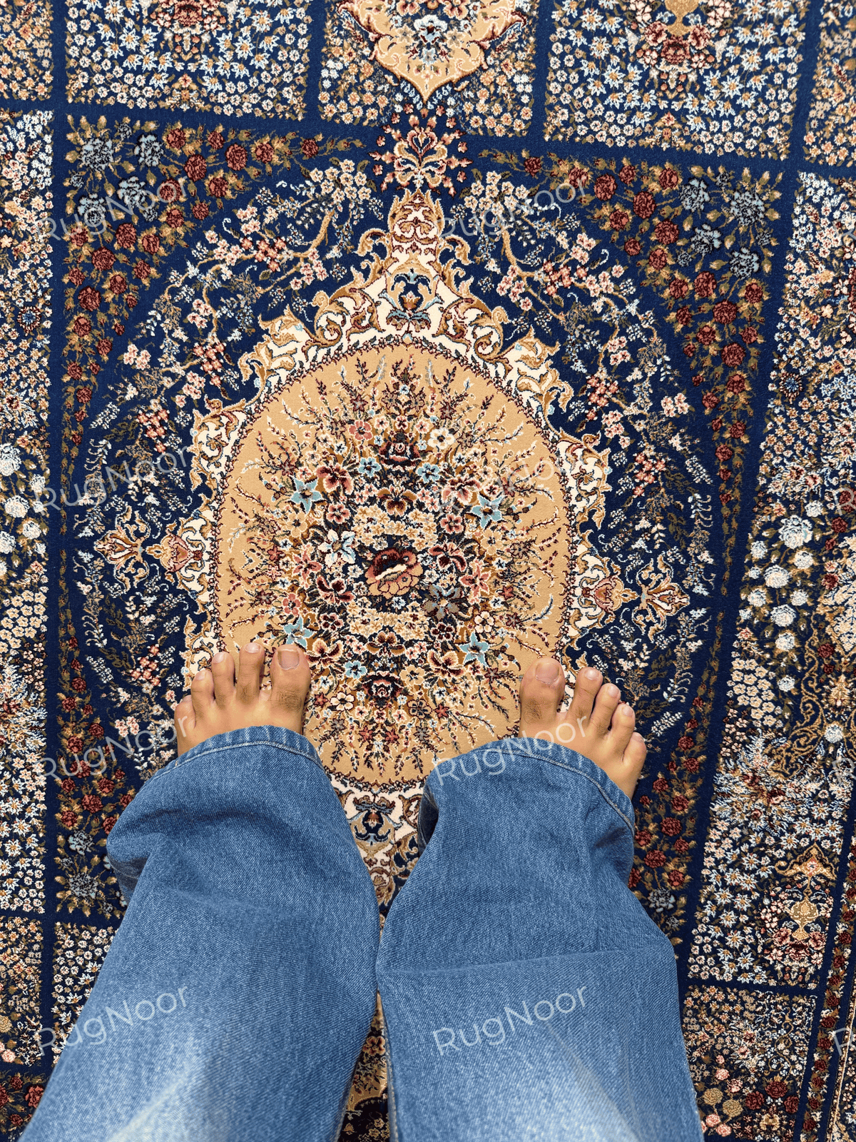 Close-up of Nayrizan's antique-gold oval medallion and multicolour floral detailing.