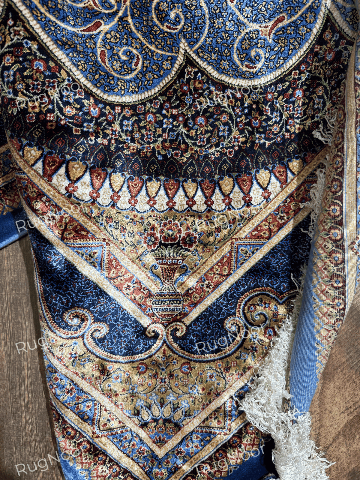 Close-up of Yasamin rug's navy floral border with ivory, rust, and gold accents.